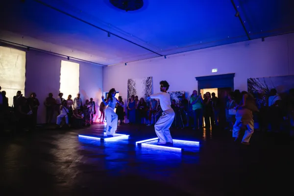 Menschen tanzen in einem Ausstellungsraum