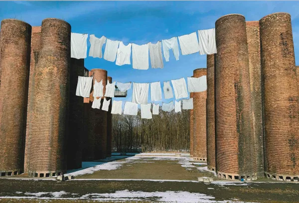 White laundry hanging between industry chimneys